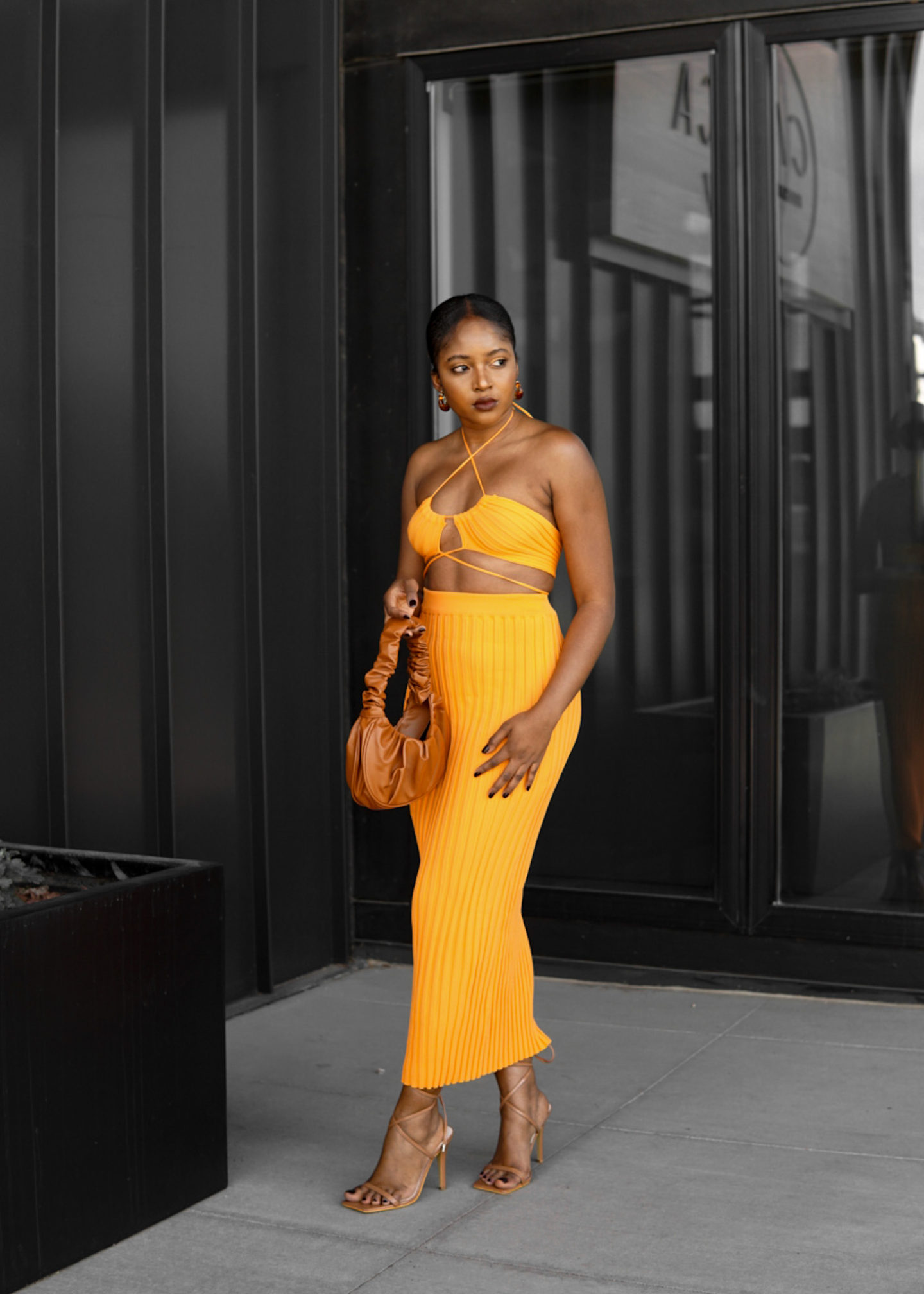 aesthetic woman poses orange two piece spring summer look brown bag nude shoes